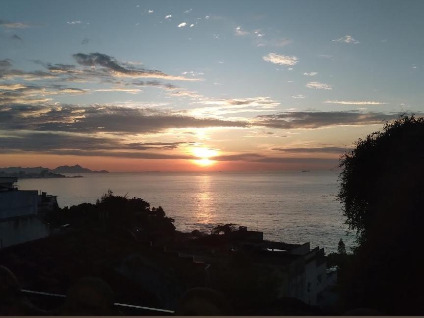 einen Sonnenuntergang über dem Meer mit Sonnenuntergang in der Unterkunft Favela Suite Quartos Camas Quitinetes para Rapazes Alto Vidigal in Rio de Janeiro