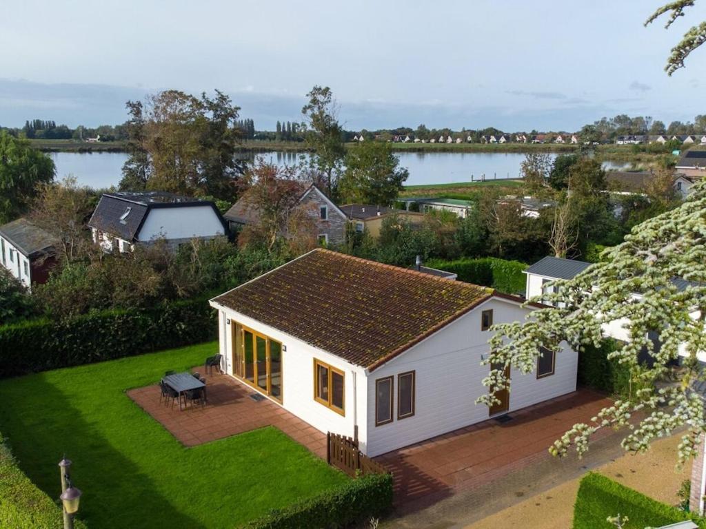 a small white house with a view of a lake at Wilgenroos Vakantiepark De Groote Vliet in Wervershoof