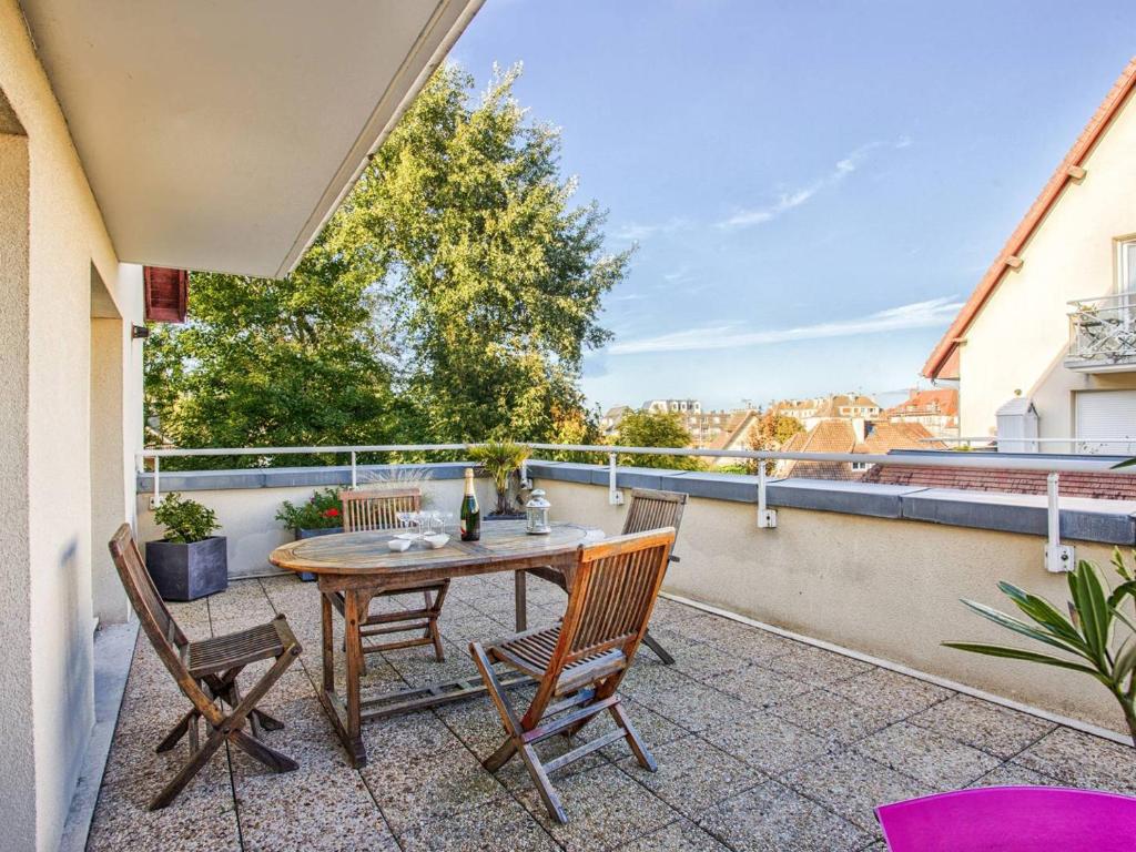 un patio avec une table et des chaises sur un balcon dans l'établissement Appartement spacieux 70m², piscine, parking, près plage et commerces - FR-1-788-38, à Merville-Franceville-Plage