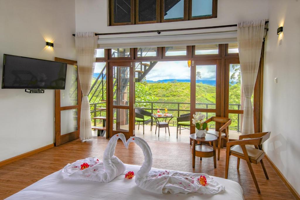 a room with two swans on a bed with a view at La Casa Lindula Villa Ceylon in Lindula