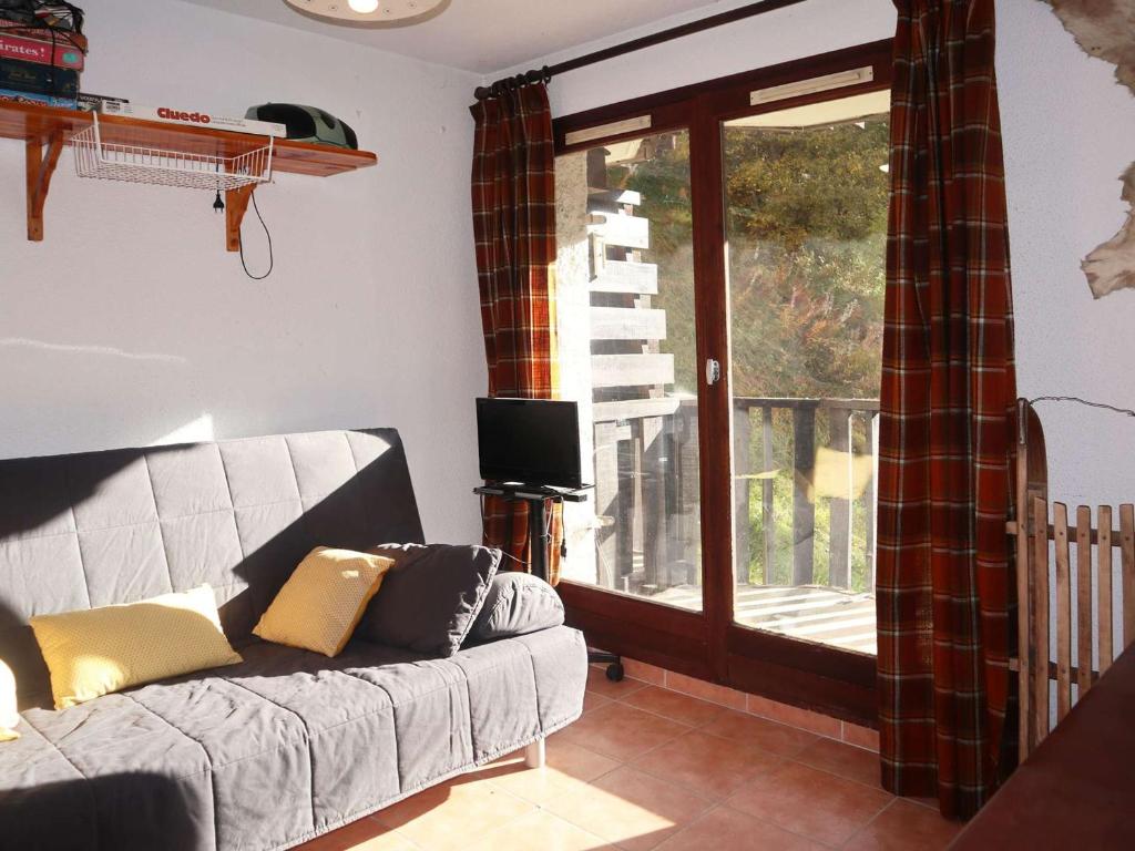 un salon avec un canapé et une porte coulissante en verre dans l'établissement Charmant studio skis aux pieds pour 4 pers. aux Orres - FR-1-322-651, aux Orres