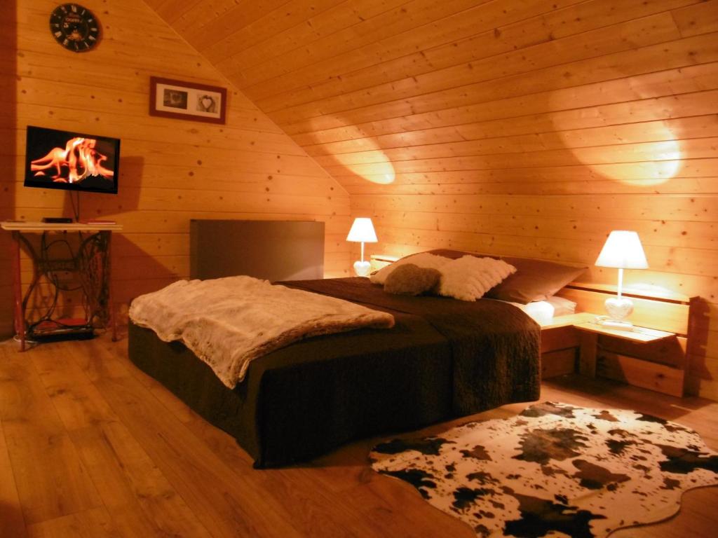 een slaapkamer met een bed in een houten hut bij Gite Au Coeur Du Chalet en Belledonne vers Prapoutel Les 7 Laux in Sainte-Agnès