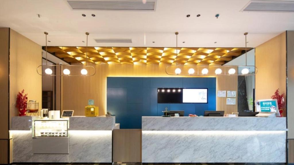 a lobby with a reception desk in a building at 宜尚酒店 日月广场骑楼老街店 in Haikou