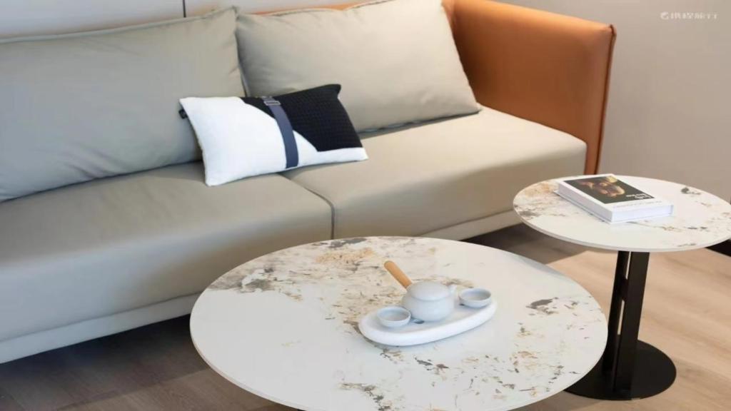 a living room with a couch and two tables at 宜尚酒店 日月广场骑楼老街店 in Haikou