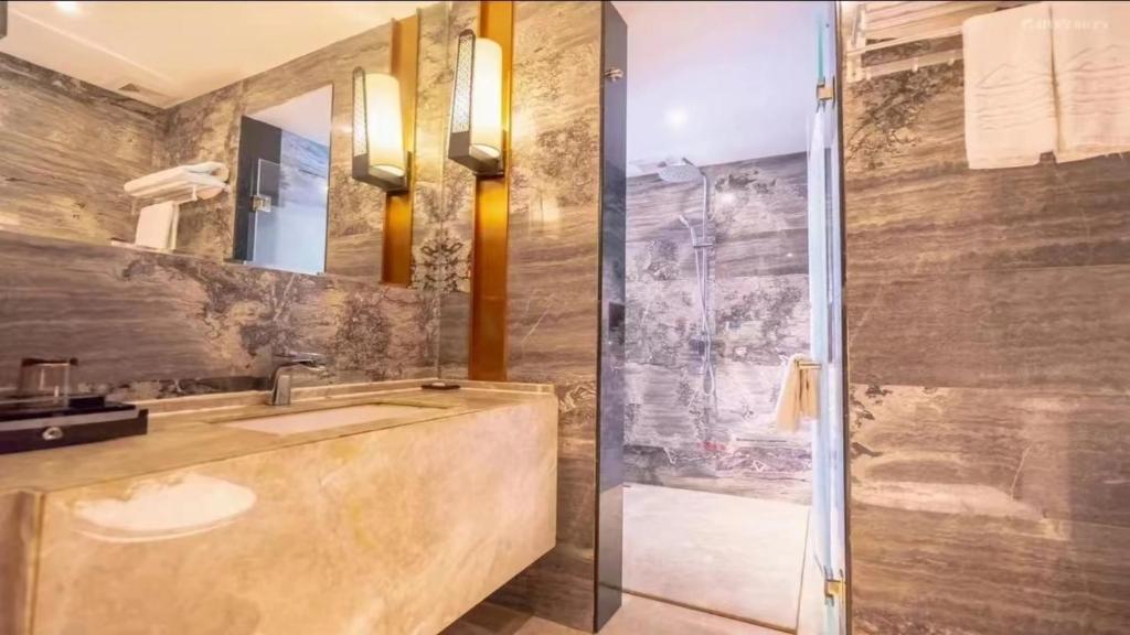 a bathroom with a sink and a shower at 宜尚酒店 日月广场骑楼老街店 in Haikou