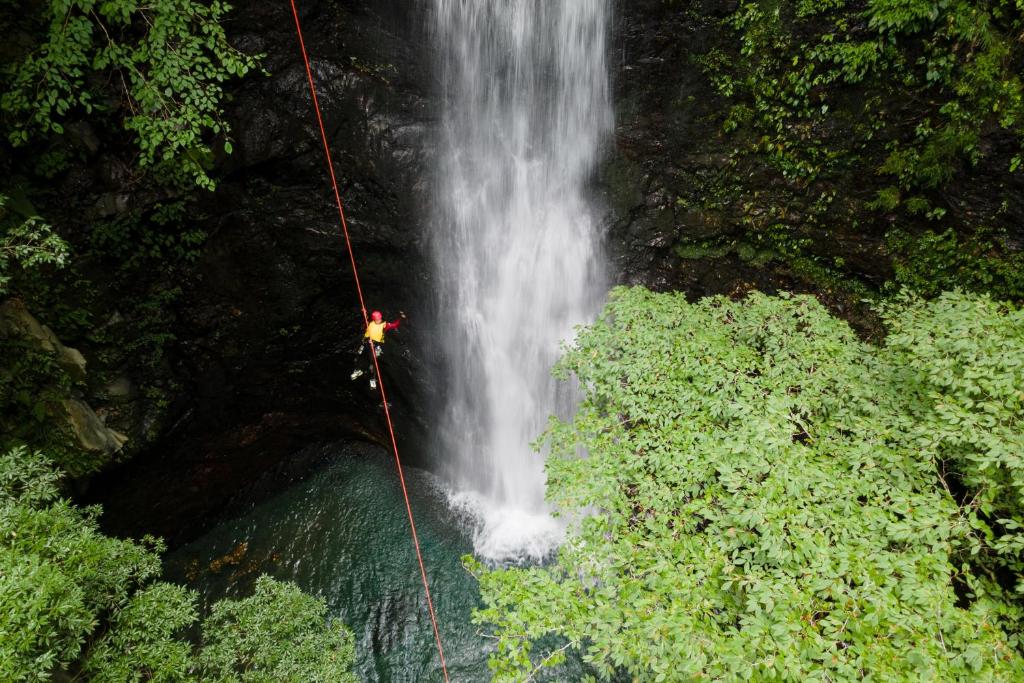 a person on a rope hanging from a waterfall at JW Marriott Hotel Nara in Nara