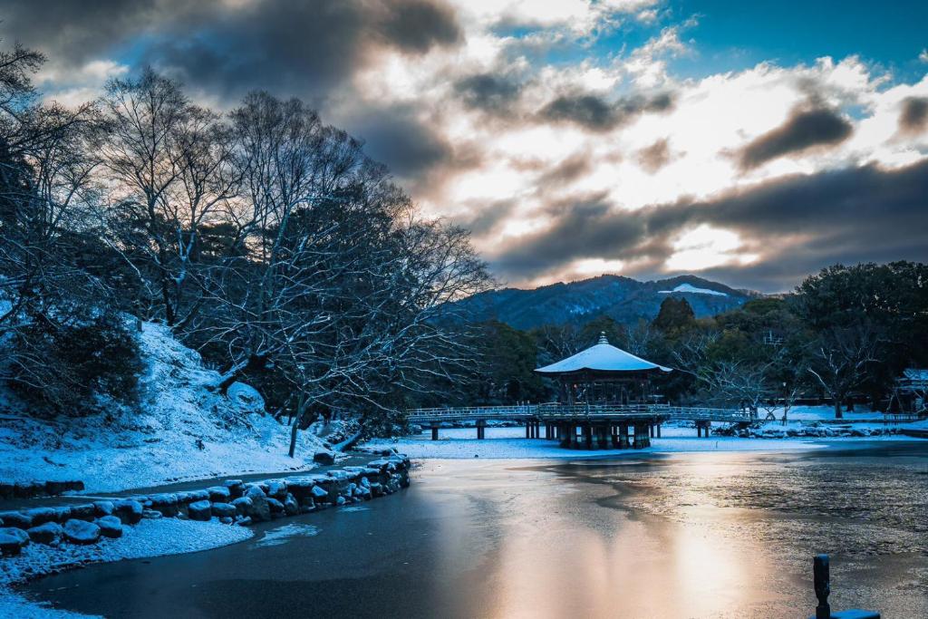 a winter scene of a river with a gazebo at JW Marriott Hotel Nara in Nara