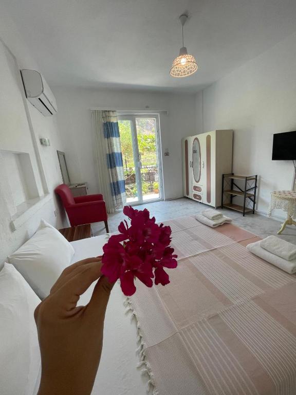 a person holding a bunch of red flowers on a bed at Mermaid in Marmaris