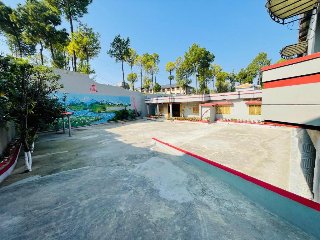 an empty tennis court in front of a building at Roomy star resorts in Abbottābād