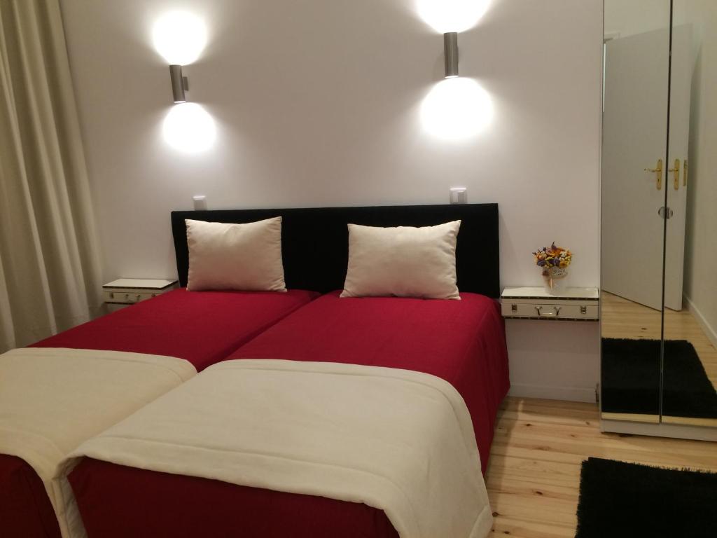 1 dormitorio con 1 cama roja grande y 2 almohadas en Clerigos-H, en Oporto