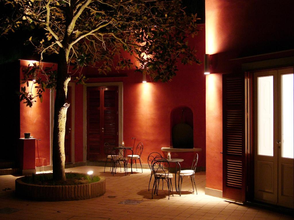 a patio with chairs and a table and a tree at Albergo 'La Vigna' in Procida