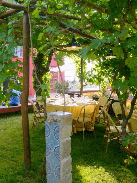 a table and chairs under a tree in a yard at Albergo 'La Vigna' in Procida