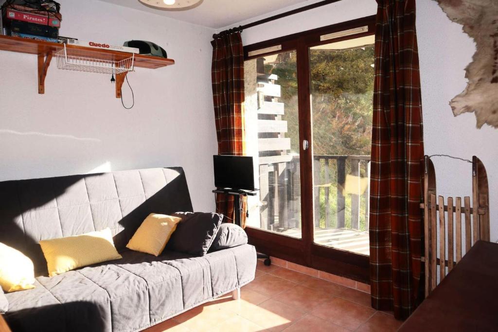 un salon avec un canapé et une grande fenêtre dans l'établissement Résidence L'oustal - Grand studio 4 personnes MAE-0121, aux Orres