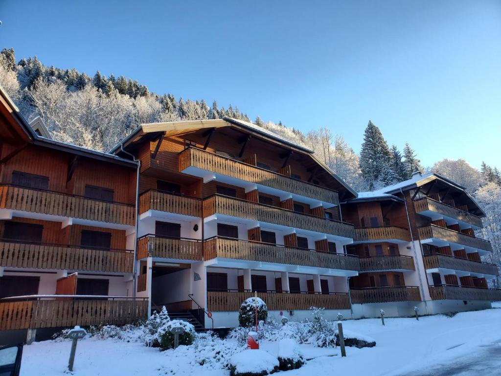 un grand bâtiment avec de la neige au sol dans l'établissement 2 pieces Morzine, à Morzine