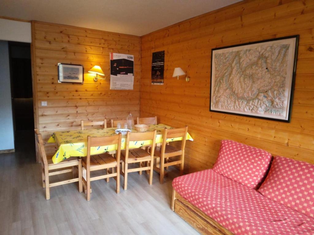 une salle à manger avec une table, des chaises et un canapé dans l'établissement Résidence Les Glaciers 3 - 3 Pièces pour 7 Personnes 191, à Aime La Plagne