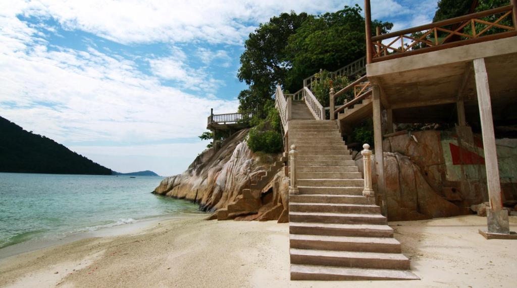 una rampa di scale su una spiaggia vicino all'acqua di Cozy Resort a Isole Perhentian