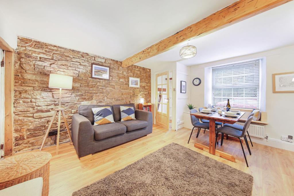 a living room with a couch and a table at Host & Stay - Batemill Cottage in Birch Vale
