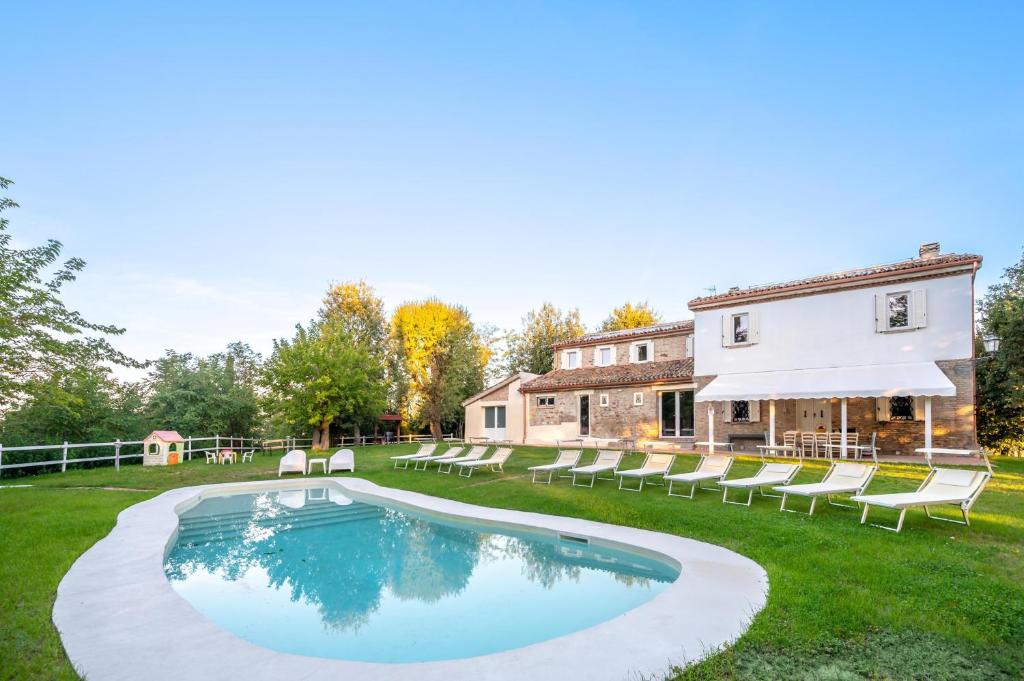 an estate with a swimming pool in front of a house at Villa ai Caprioli Mondaino in Mondaino