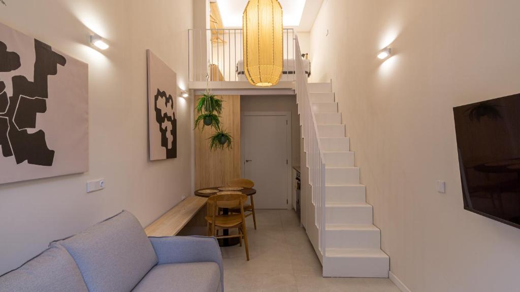 a living room with a staircase and a blue couch at Osito Hub - Poeta Durán in Valencia