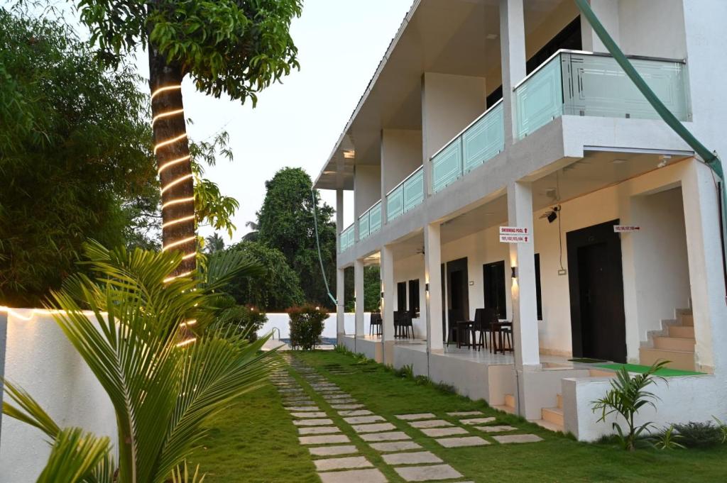 a building with a palm tree in front of it at Golden Pearl Resort By Gemstone Hospitality in Alibag