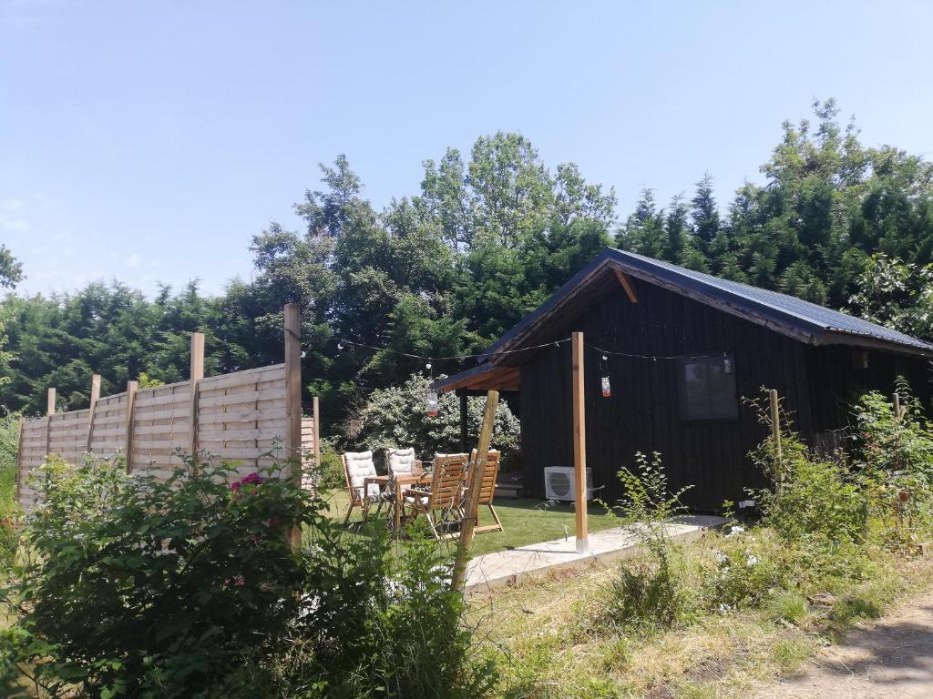 une cabane avec une table et des chaises dans la cour dans l'établissement Charmante cabane à la ferme, à 15 min de Moissac, à Moissac