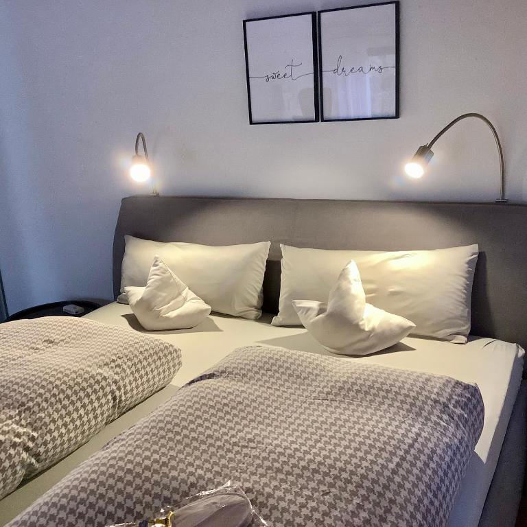 two beds with white pillows in a room at Appartement 51 in Schwäbisch Hall