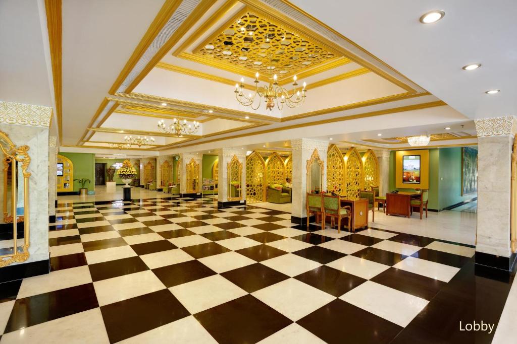 a lobby with a checkerboard floor and a chandelier at Hotel Clarks Shiraz in Agra
