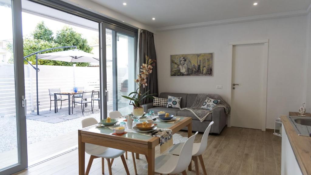 a dining room and living room with a table and chairs at La Casa Di Marty Per 9 - Belcantovillas in Torre del Lago Puccini