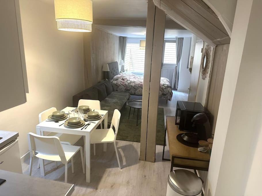 ein Wohnzimmer mit einem Tisch und ein Zimmer mit einem Bett in der Unterkunft Résidence Champenoise 1 , Troyes - France in Troyes