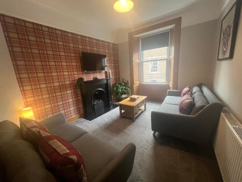 a living room with a couch and a fireplace at The TWEED in the centre of Melrose in Melrose