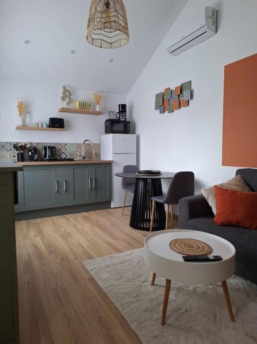 un salon avec un canapé et une table dans l'établissement Charmante maisonnette équipée, à Caudebec-lès-Elbeuf