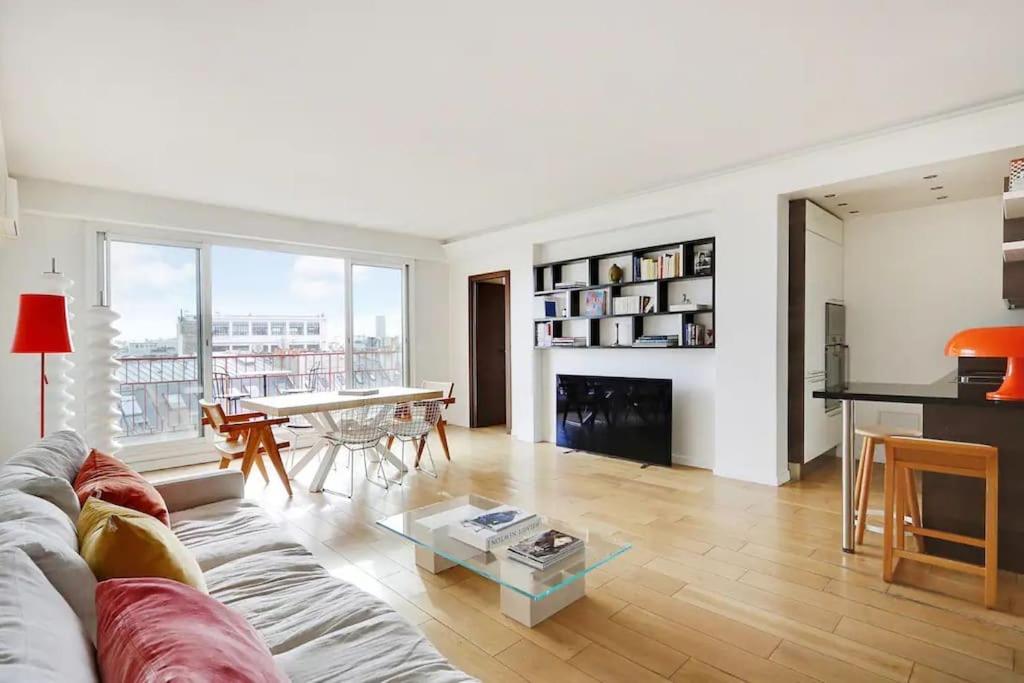 un salon avec un canapé et une table dans l'établissement Penthouse Champs Élysées, vue sur tout Paris et la Tour Eiffel, à Paris