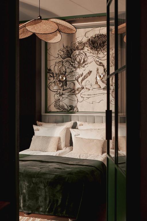 Hotel DOKI Living - Foodhall & Parking by Downtown Apartments, a bedroom with a bed with a painting on the wall at DOKI Living - Foodhall & Parking by Downtown Apartments in Gdańsk