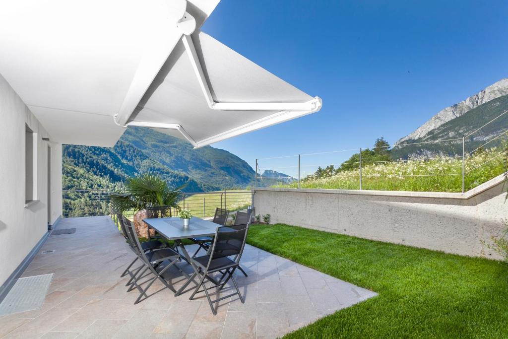 a patio with a table and chairs and a view of mountains at Molveno Bellavista - Lake in Molveno