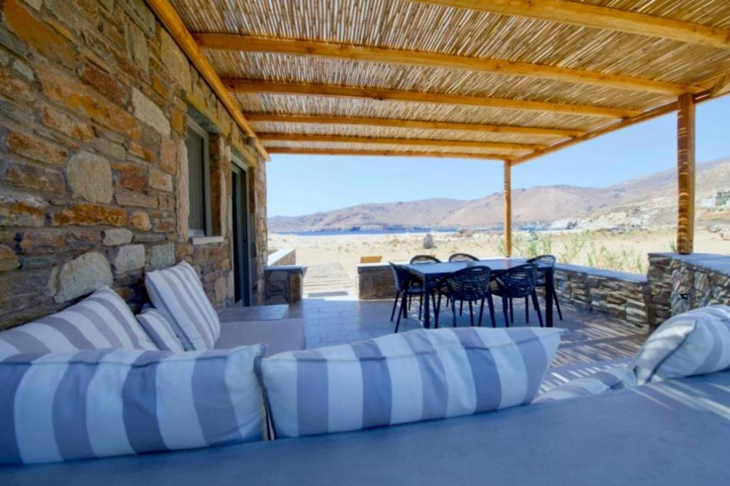 a patio with chairs and tables and a stone wall at Ammoa Beach Residences in Vayiá