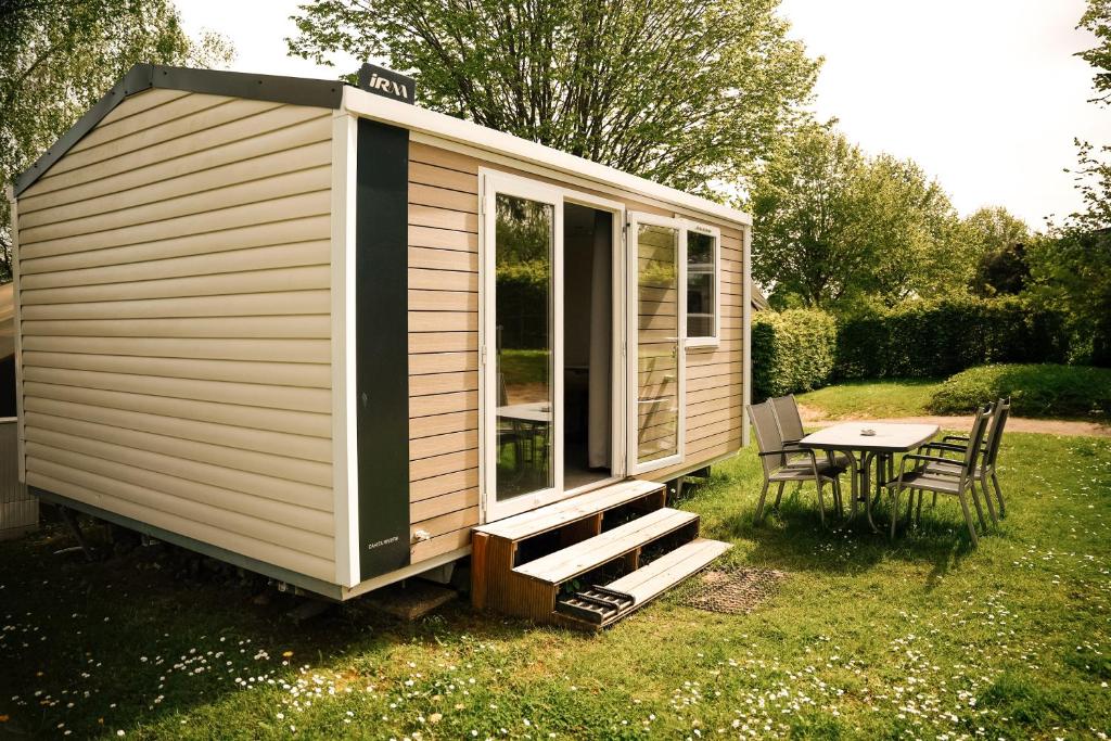a tiny house with a table and chairs in a yard at Cahita Camping Belle-Vue 2000 in Berdorf