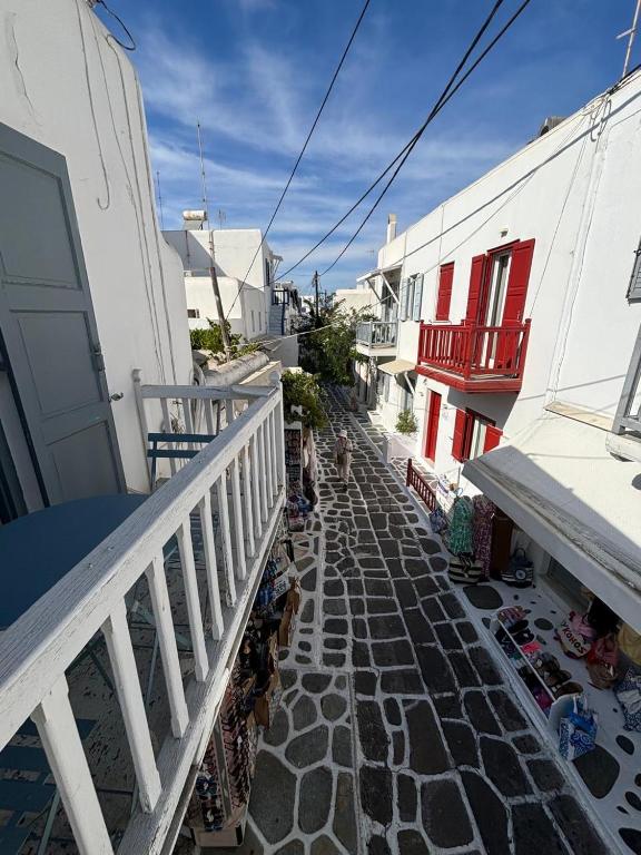 a stone walkway between two buildings with a balcony at Myconian Avra Apartment in Mikonos