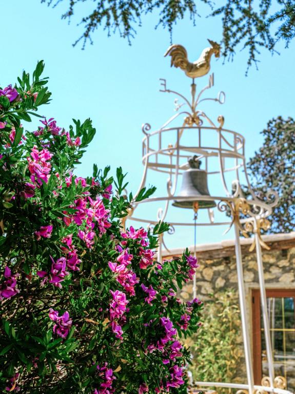 a bell in front of a building with flowers at La Chèvre d'Or in Éze