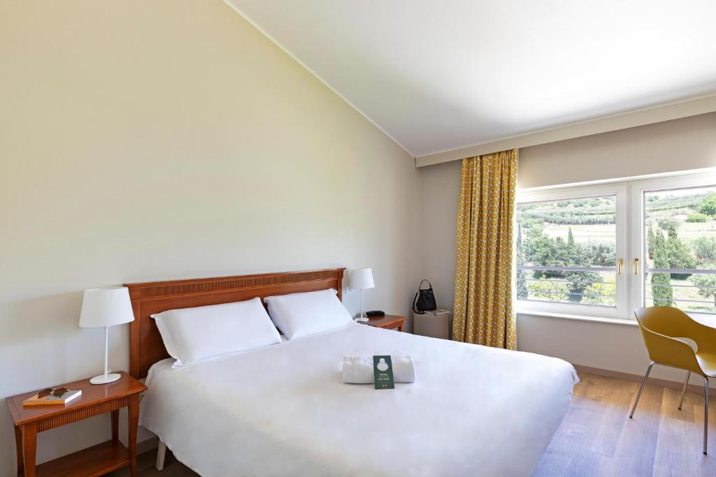 阿菲B&B Hotel Affi - Lago di Garda的卧室里有一张白色的大床和一扇窗户