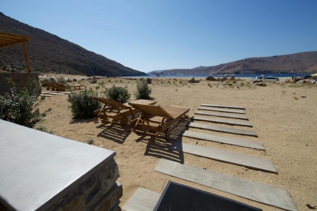 a group of chairs and tables on a sandy beach at Ammoa Beach Residences in Vayiá