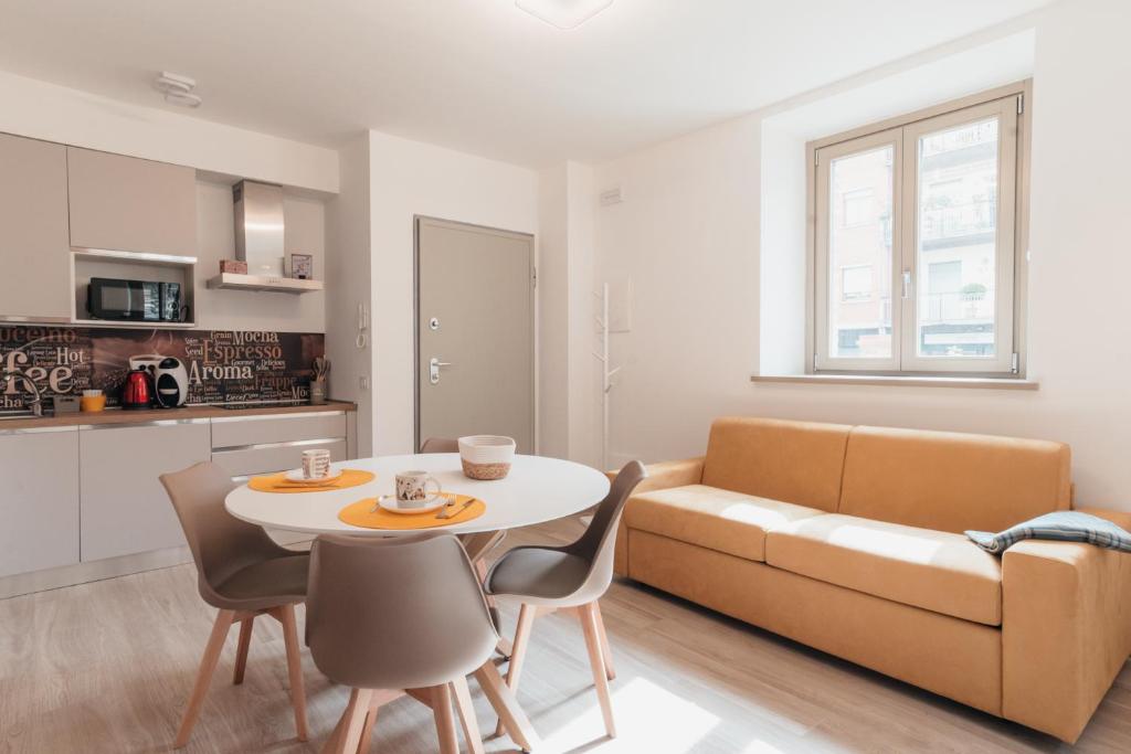 a living room with a couch and a table and chairs at Via Roma 34 in Castiglione del Lago