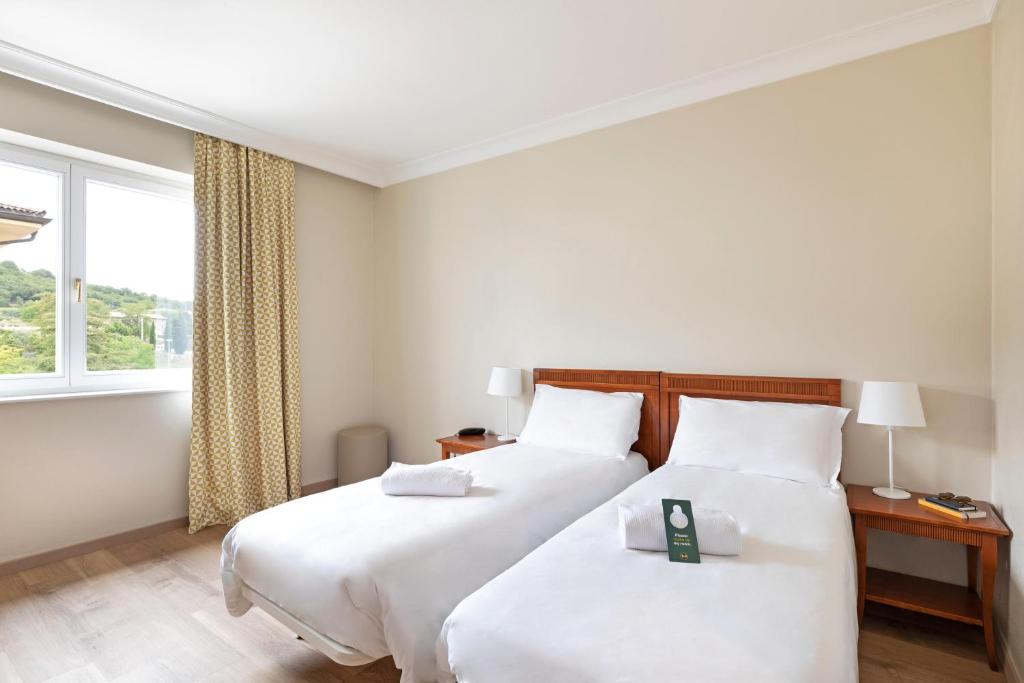 una camera da letto con due letti e una finestra di B&B Hotel Affi - Lago di Garda a Affi