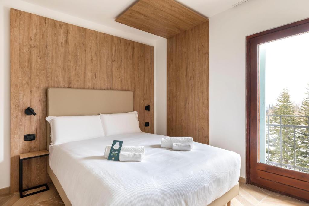 Кровать или кровати в номере B&B Hotel Passo Tre Croci Cortina