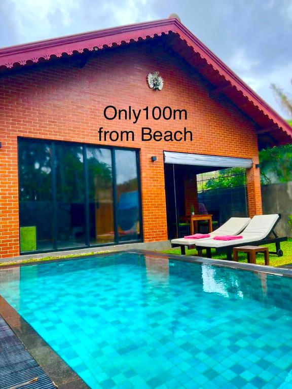 a resort with a swimming pool in front of a building at Negombo Morawala Beach Villa in Negombo
