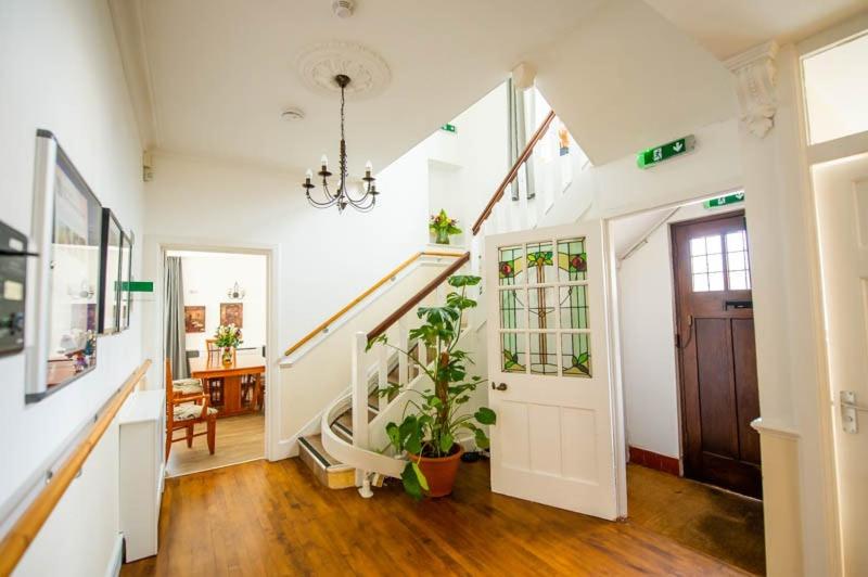 a hallway with a staircase and a door with plants at Canford house on Westbury on Trym in Bristol