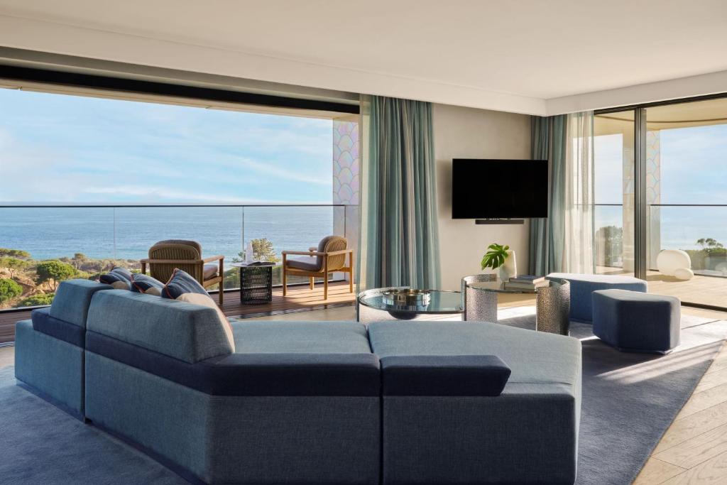 a living room with a blue couch and a view of the ocean at W Algarve in Albufeira