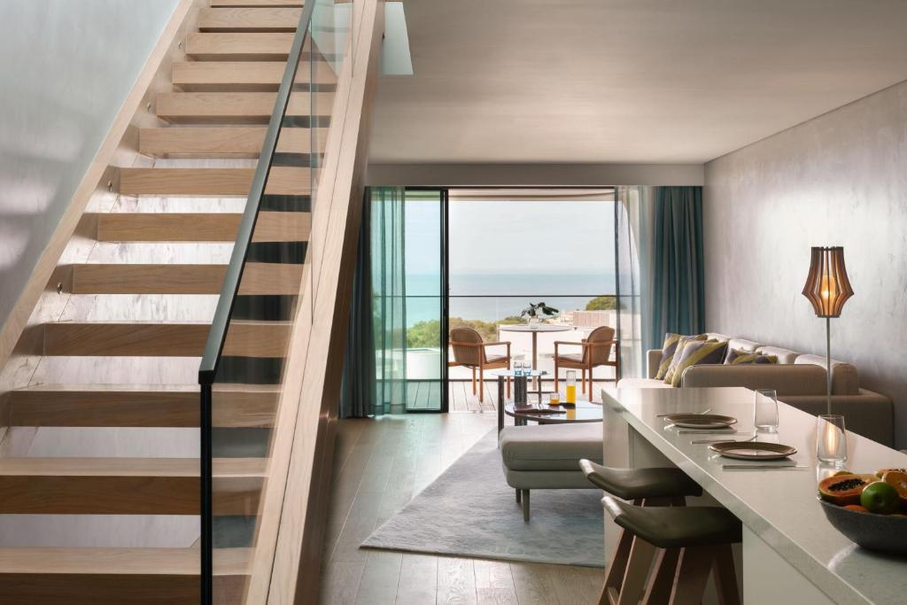 a staircase in a living room with a view of the ocean at W Algarve in Albufeira