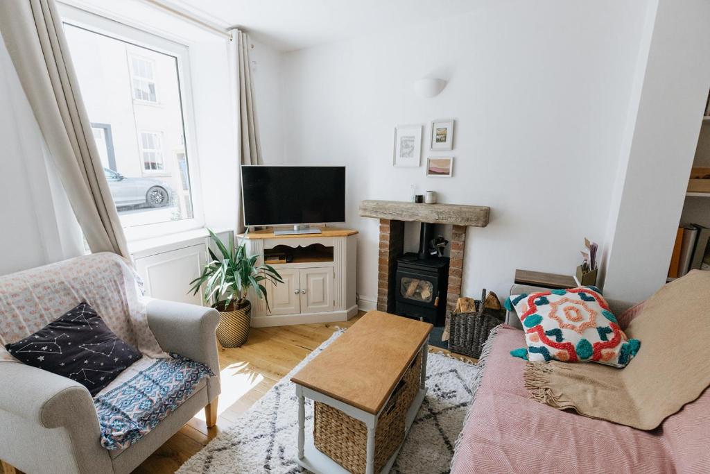 a living room with a couch and a fireplace at SUN COTTAGE - Cosy Cottage in Ulverston with a log burner in Ulverston, Cumbria in Ulverston