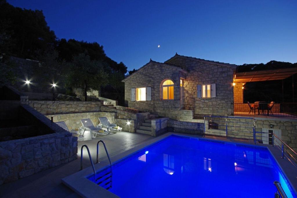 a swimming pool in front of a house at night at House Tonko in Postira
