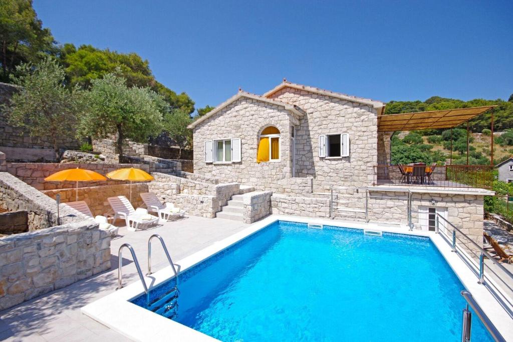 a villa with a swimming pool and a house at House Tonko in Postira